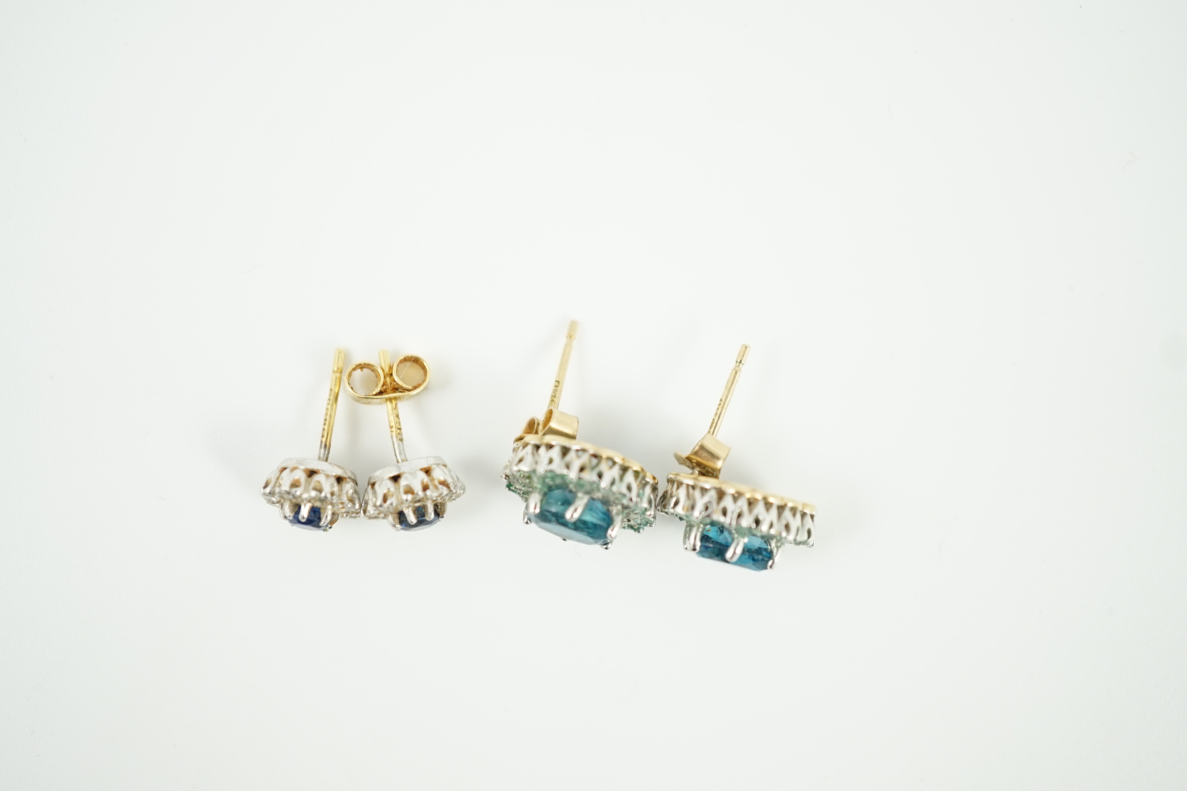 A modern pair of 18ct gold, sapphire and diamond cluster set ear studs, 8mm, gross weight 2.7 grams and a pair of 9ct ear studs, gross 3 grams.